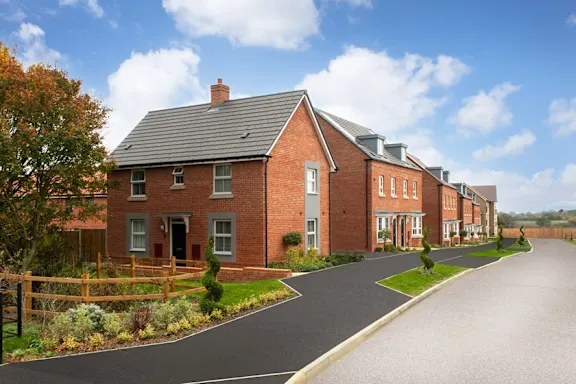 A row of red brick houses with a driveway in front.